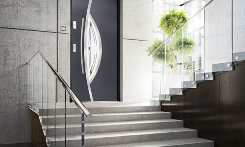 Nowoczesne antracytowe drzwi zewnętrzne z pionowymi przeszkleniami i długim pochwytem ze stali nierdzewnej w jasnej elewacji – realizacja Ronix II Lędziny